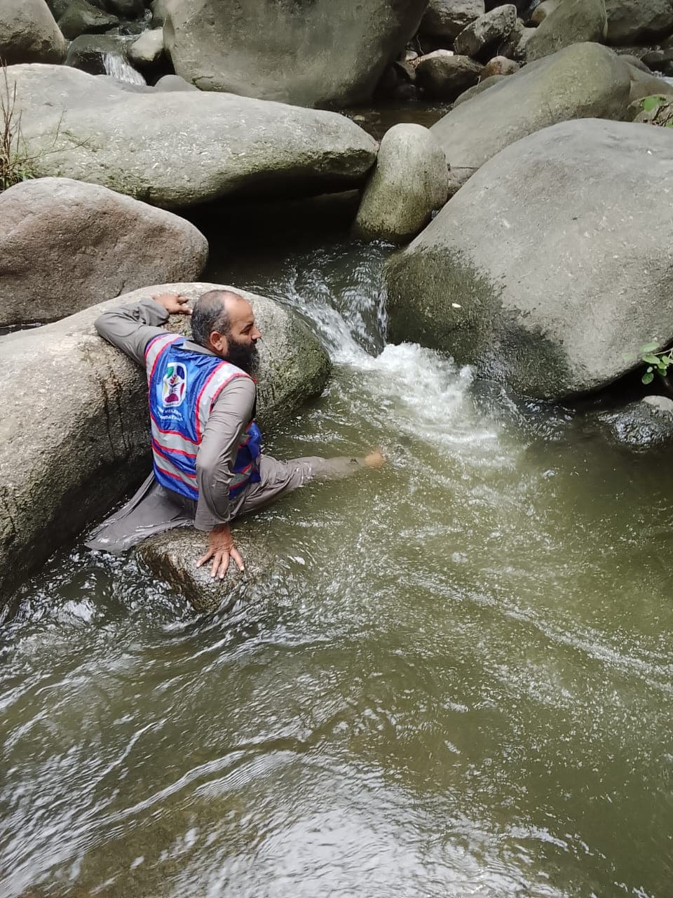 Combing the riverbank for a missing person after the floods hit the Oghi area.